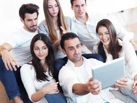 group of friends taking selfie photo with tablet at modern home indoors