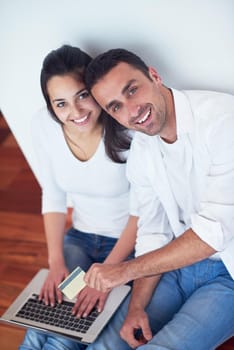 happy young relaxed  couple working on laptop computer at modern home interior