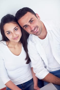 happy young relaxed  couple working on laptop computer at modern home interior