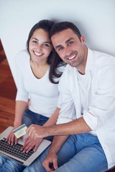 happy young relaxed  couple working on laptop computer at modern home interior