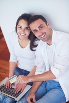 happy young relaxed  couple working on laptop computer at modern home interior