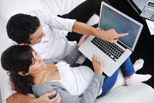 joyful couple relax and work on laptop computer at modern living room indoor home