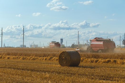 Combine harvester harvesting ripe wheat on sunny summer day.