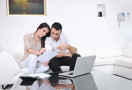 joyful couple relax and work on laptop computer at modern living room indoor home