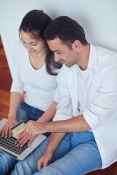 happy young relaxed  couple working on laptop computer at modern home interior