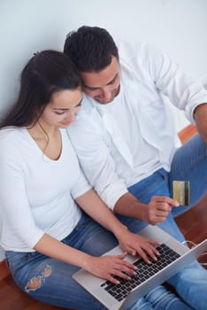 happy young relaxed  couple working on laptop computer at modern home interior