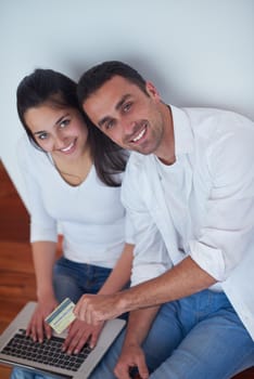 happy young relaxed  couple working on laptop computer at modern home interior