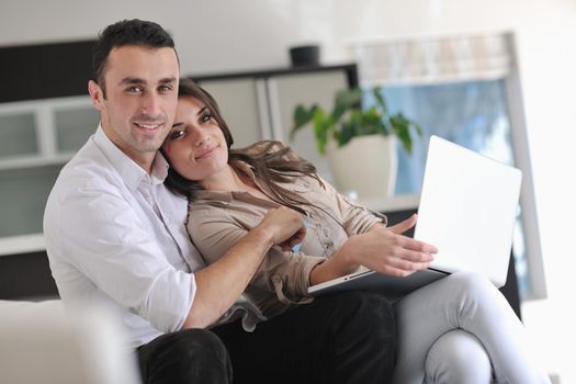 joyful couple relax and work on laptop computer at modern living room indoor home