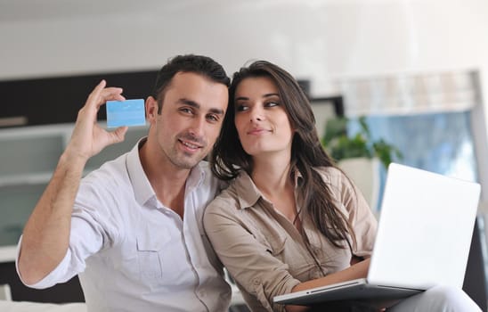 joyful couple relax and work on laptop computer at modern living room indoor home