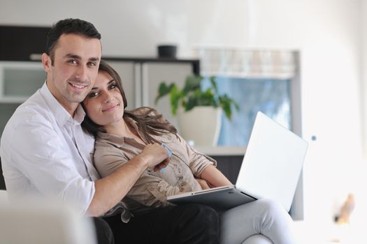 joyful couple relax and work on laptop computer at modern living room indoor home