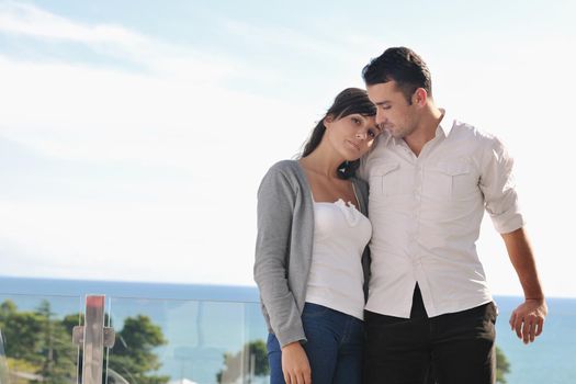 happy young couple in love have romance  relax on balcony outdoor with ocean and blue sky in background