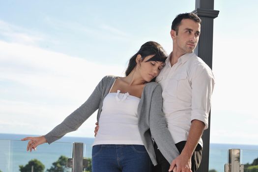 happy young couple in love have romance  relax on balcony outdoor with ocean and blue sky in background