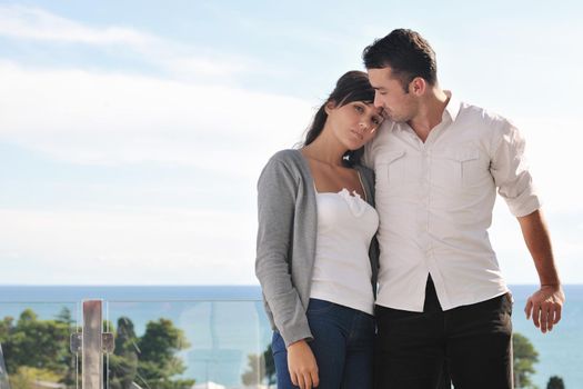 happy young couple in love have romance  relax on balcony outdoor with ocean and blue sky in background