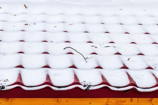 A thin layer of snow on the roof tile. Winter weather concept.
