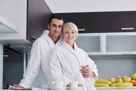 happy young couple have fun in  modern kitchen indoor  while preparing fresh fruits and vegetables food salad