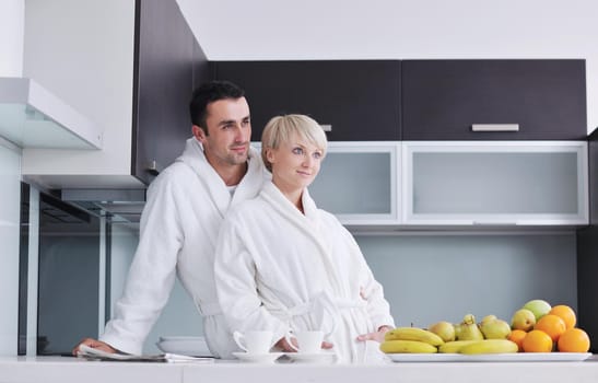 happy young couple have fun in  modern kitchen indoor  while preparing fresh fruits and vegetables food salad