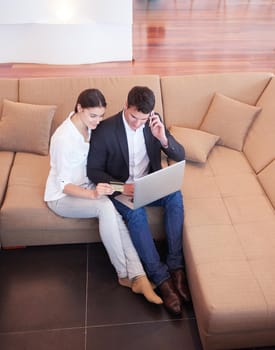 happy young relaxed  couple working on laptop computer at modern home interior