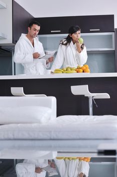 young family couple read newspaper at kitchen in morning with  fresh breakfast  fruits food and coffee drink on table