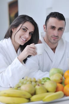 happy young couple have fun in  modern kitchen indoor  while preparing fresh fruits and vegetables food salad