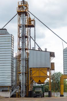 Modern Granary elevator and seed cleaning line. Silver silos on agro-processing and manufacturing plant for storage and processing drying cleaning of agricultural products, flour, cereals and grain.