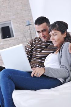 joyful couple relax and work on laptop computer at modern living room indoor home