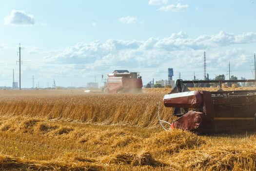 Combine harvester harvesting ripe wheat on sunny summer day.