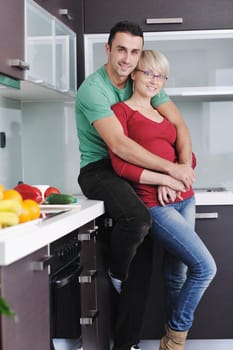 happy young couple have fun in  modern kitchen indoor  while preparing fresh fruits and vegetables food salad