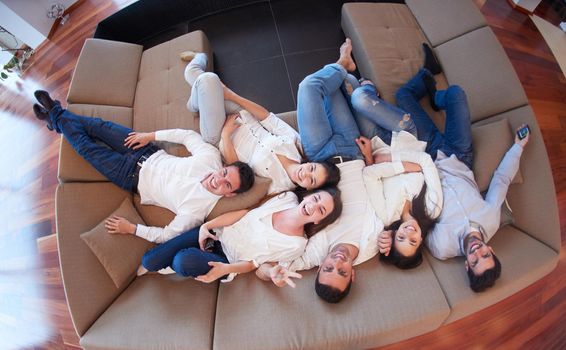 portrait of happy young group of friends get releax and have fun at modern home interior, top view