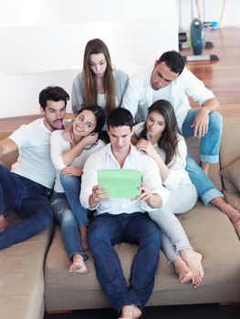 group of friends taking selfie photo with tablet at modern home indoors