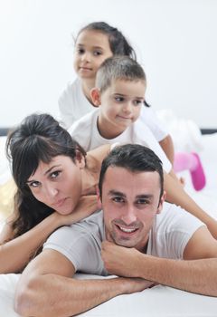 happy young Family in their bedroom have fun and play in bed