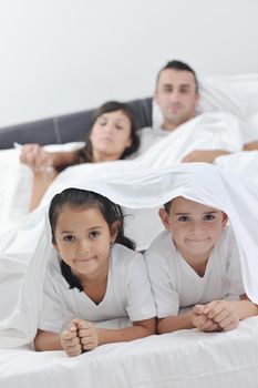 happy young Family in their bedroom have fun and play in bed