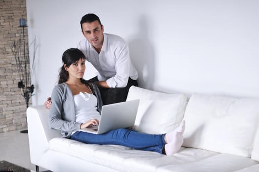 joyful couple relax and work on laptop computer at modern living room indoor home