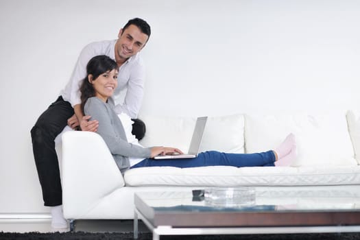 joyful couple relax and work on laptop computer at modern living room indoor home