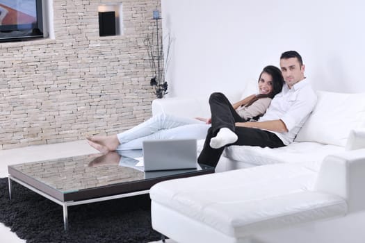 joyful couple relax and work on laptop computer at modern living room indoor home