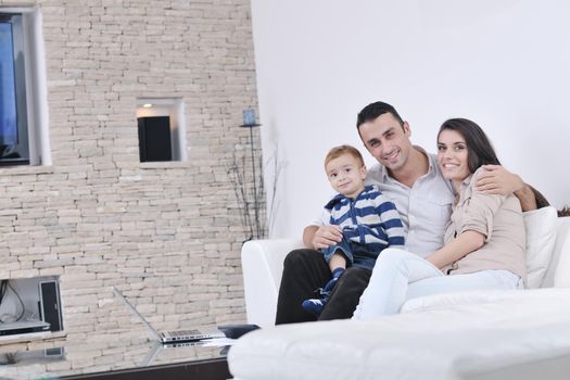 happy young family have fun and relaxing at new home with modern lcd tv in background