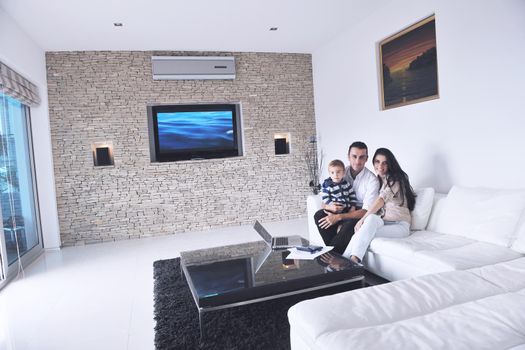 happy young family have fun and relaxing at new home with modern lcd tv in background