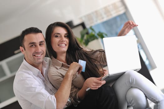 joyful couple relax and work on laptop computer at modern living room indoor home