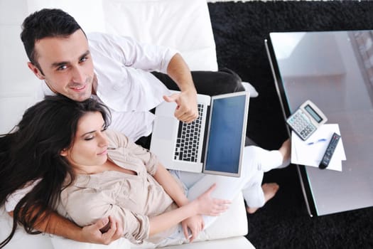 joyful couple relax and work on laptop computer at modern living room indoor home