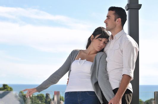 happy young couple in love have romance  relax on balcony outdoor with ocean and blue sky in background