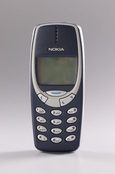 Minsk, Belarus, December 08, 2021: Cell phone Nokia 3310 blue on gray background. Old obsolete wireless phone concept