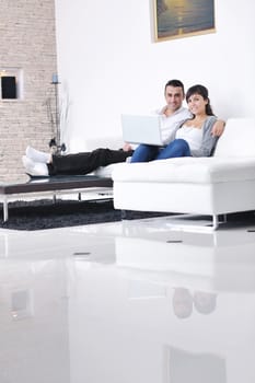 joyful couple relax and work on laptop computer at modern living room indoor home