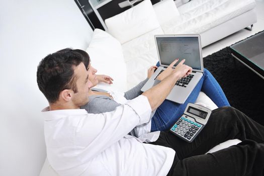 joyful couple relax and work on laptop computer at modern living room indoor home