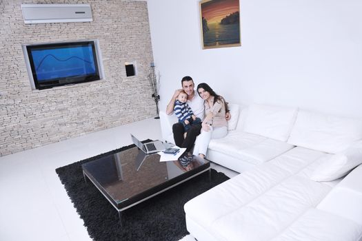 happy young family have fun and relaxing at new home with modern lcd tv in background