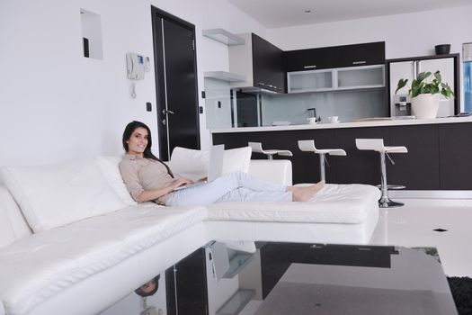 relaxed young woman working on laptop computer in bright  home indoor