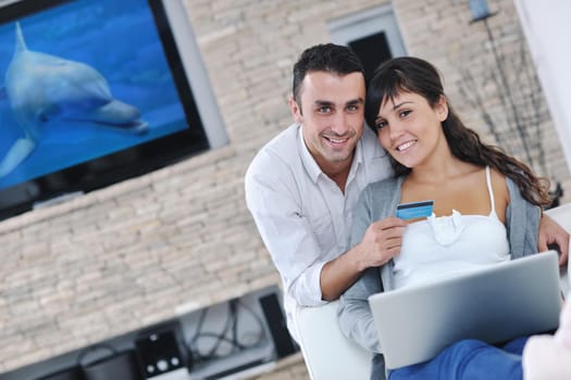 joyful couple relax and work on laptop computer at modern living room indoor home