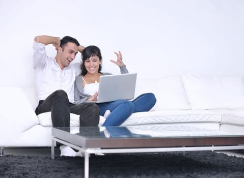 joyful couple relax and work on laptop computer at modern living room indoor home