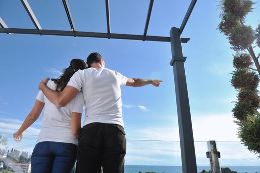 happy young couple in love have romance  relax on balcony outdoor with ocean and blue sky in background