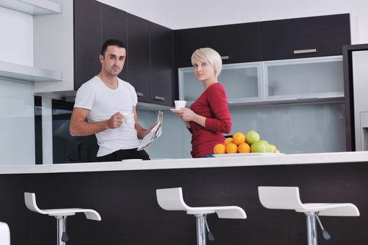 young family couple read newspaper at kitchen in morning with  fresh breakfast  fruits food and coffee drink on table