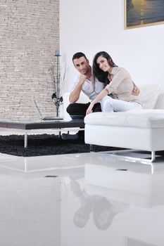 joyful couple relax and work on laptop computer at modern living room indoor home