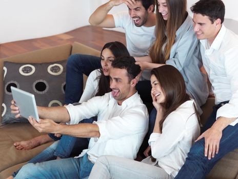 group of friends taking selfie photo with tablet at modern home indoors